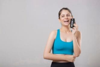 Woman holding a bottle of supplements, likely promoting wellness or health.