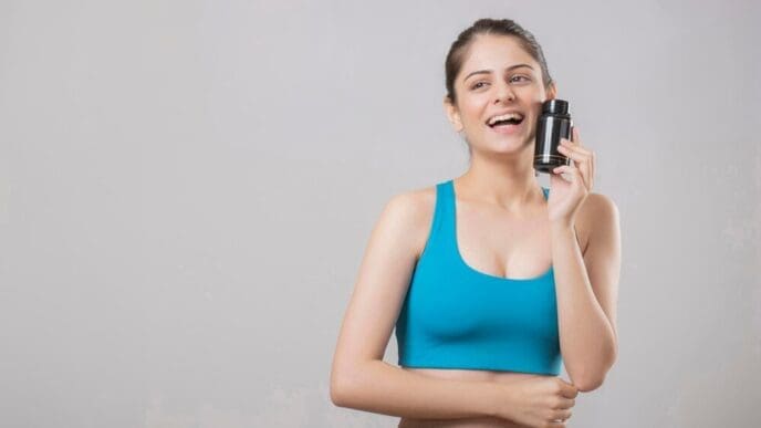 Woman holding a bottle of supplements, likely promoting wellness or health.