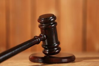Close-up of a wooden judge's gavel on a wooden table.