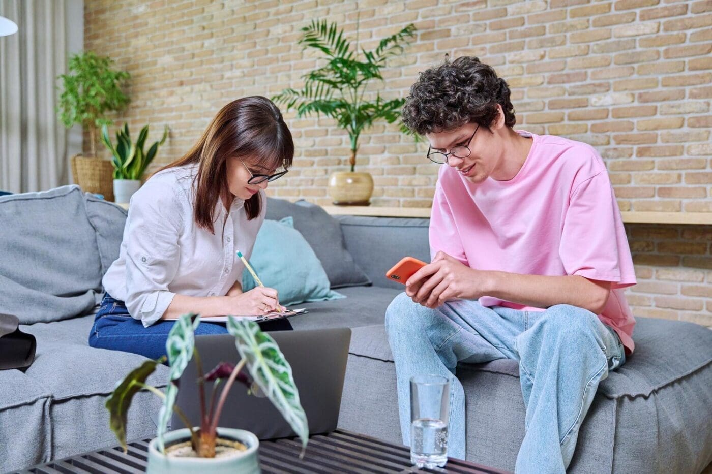 Young man smiles while talking to a psychologist in an office setting.