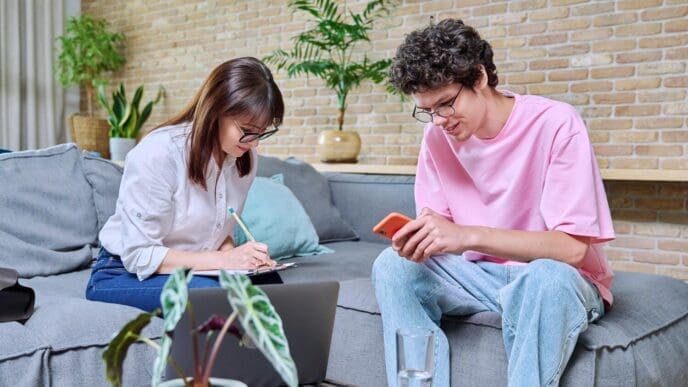Young man smiles while talking to a psychologist in an office setting.