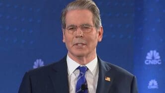 Treasury Secretary Scott Bessent speaks at a podium in a dark suit and glasses against a blue background with the CNBC logo.