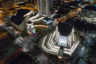 High aerial night view of the Adrienne Arsht Center for the Performing Arts complex, showing its illuminated, modern geometric architecture in Downtown Miami.