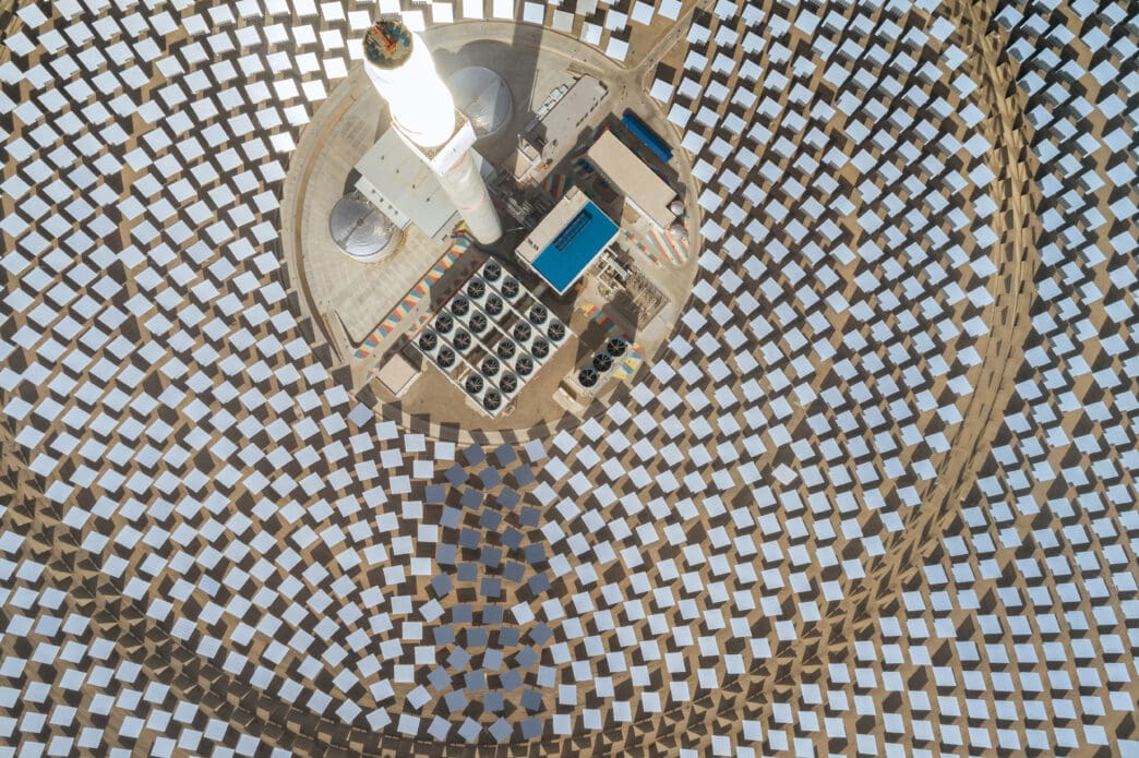 Overhead view of a concentrated solar thermal power plant, with thousands of mirrors focused on a central tower