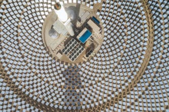Overhead view of a concentrated solar thermal power plant, with thousands of mirrors focused on a central tower