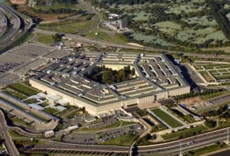High aerial view of the Pentagon building in Washington DC, showing its five concentric rings, interior courtyard, and surrounding highways.