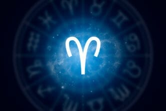 The bold white glyph for the Aries zodiac sign centered against a glowing blue nebula with a faint wheel of other signs