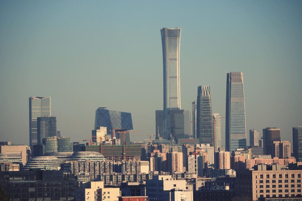 The dense urban skyline of Beijing, China, featuring the CITIC Tower and CCTV Headquarters.