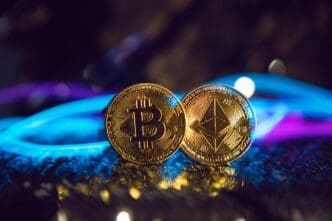 Two gold cryptocurrency coins, Bitcoin and Ethereum, resting on a reflective surface surrounded by glowing blue and purple neon light.