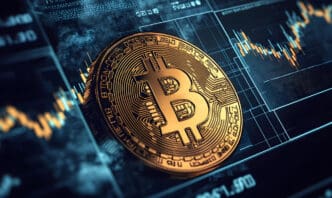 A close-up of a golden Bitcoin coin rests on a digital display showing stock market charts