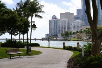 Walkway on Brickell Key, Miami, with bench, water view, and Brickell skyline.