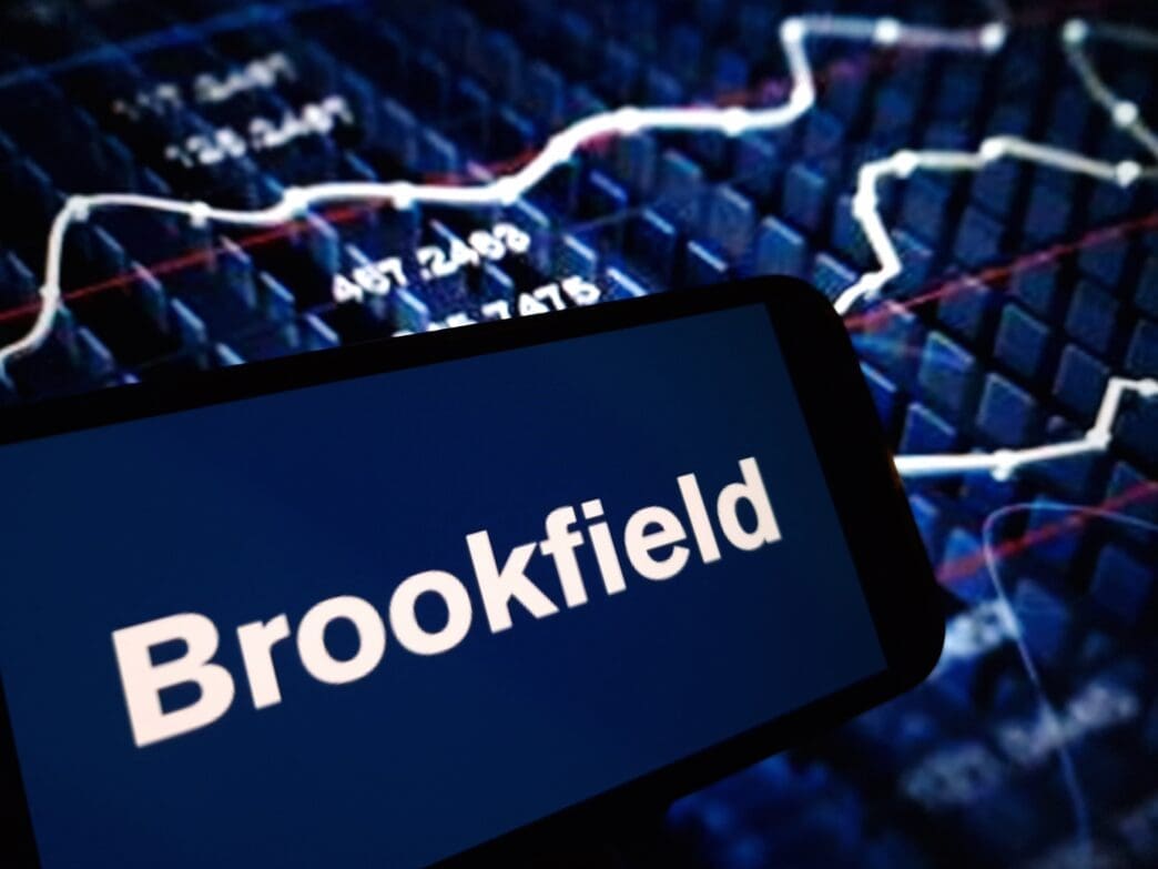 The Brookfield Property Partners logo is shown on a smartphone screen, with a blurry blue digital stock chart in the background.