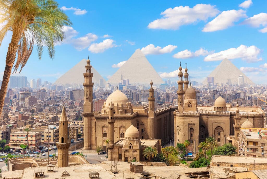 View of the Mosque-Madrassa of Sultan Hassan in Cairo, with the Pyramids of Giza behind.