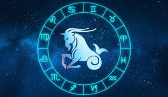 A neon blue circle displays twelve zodiac symbols around a central image of the Capricorn goat, set against a starry galaxy background.
