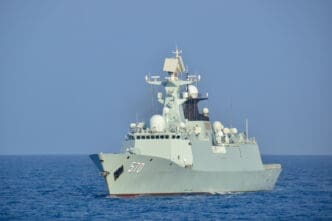 The Chinese Navy's guided-missile frigate PLAN Huangshan (FFG-570) sailing on calm blue open water.