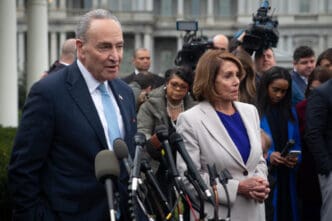 Democratic leaders Chuck Schumer and Nancy Pelosi stand before microphones to address the media outside the White House.
