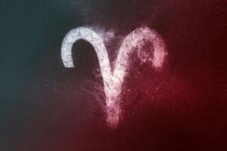 The stylized zodiac symbol for Aries glowing white against a dark cosmic background split into red and teal colors.