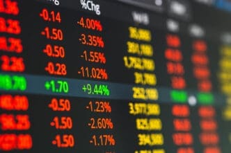 Close-up view of a dark digital stock market screen showing numerous assets with prices and steep negative percentage changes in red and orange.