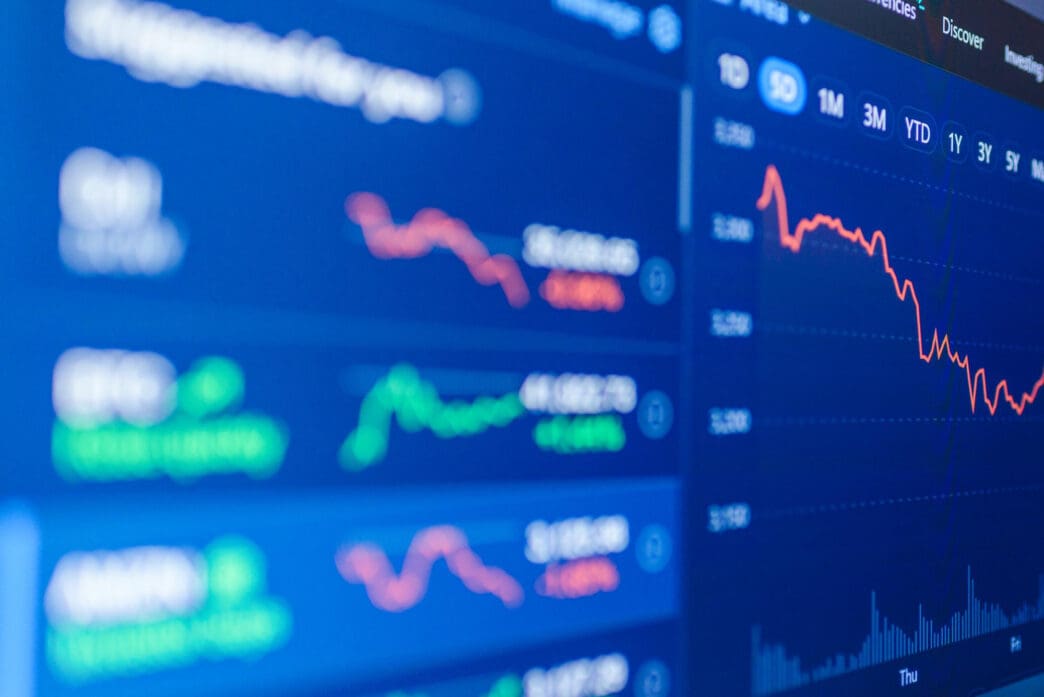 A close-up of a digital screen showing a declining red stock market chart.