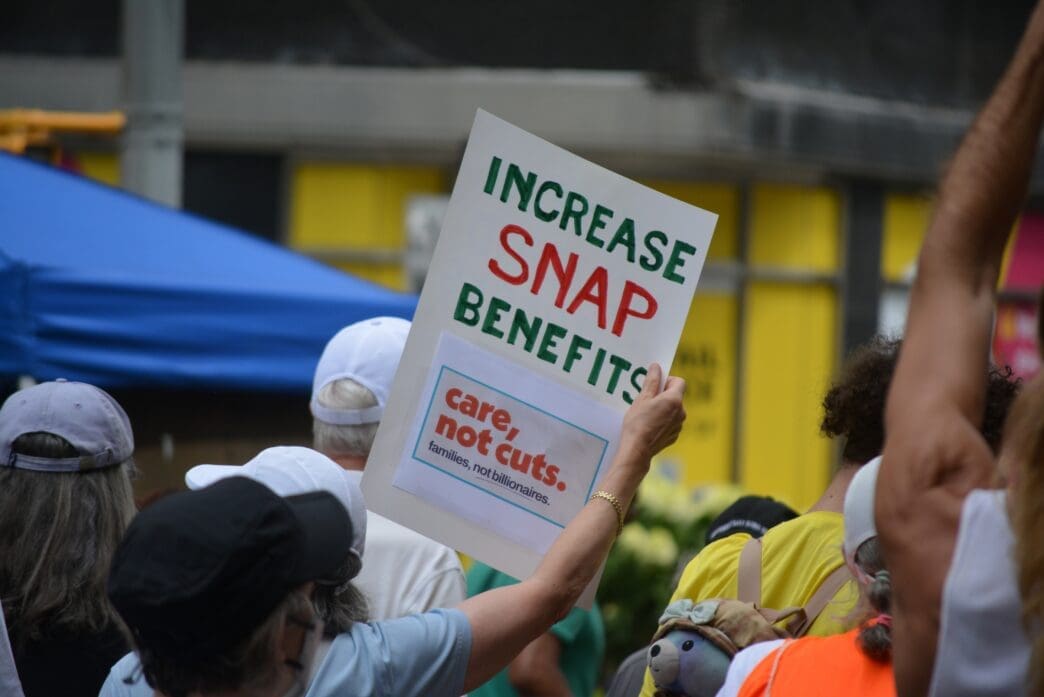 Protester's sign reads 'Increase SNAP Benefits' at a Disability Rights march.