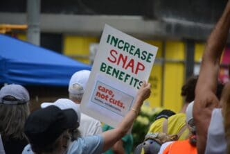 Protester's sign reads 'Increase SNAP Benefits' at a Disability Rights march.