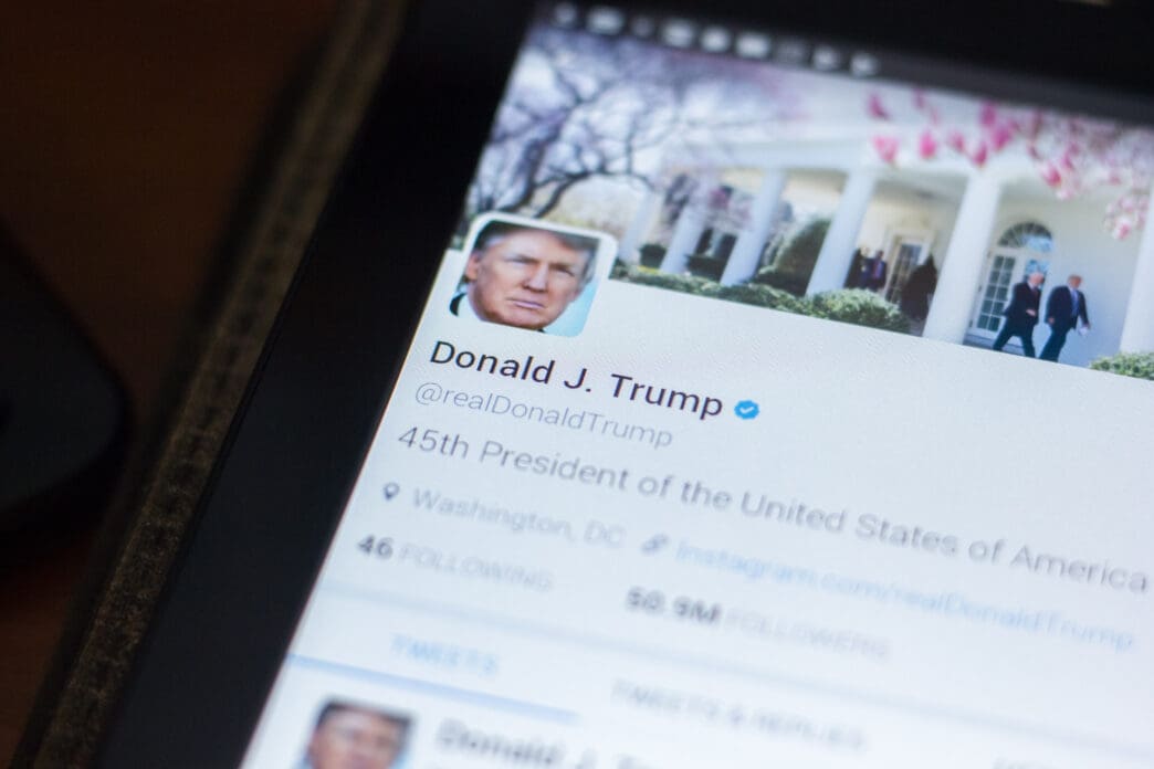 A close-up of a tablet screen showing the @realDonaldTrump Twitter profile.