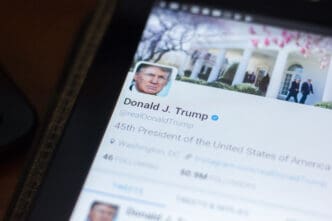 A close-up of a tablet screen showing the @realDonaldTrump Twitter profile.