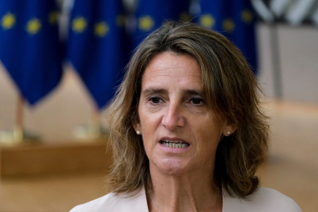 European Commission Vice President Teresa Ribera speaking in front of EU flags in Brussels, Belgium.