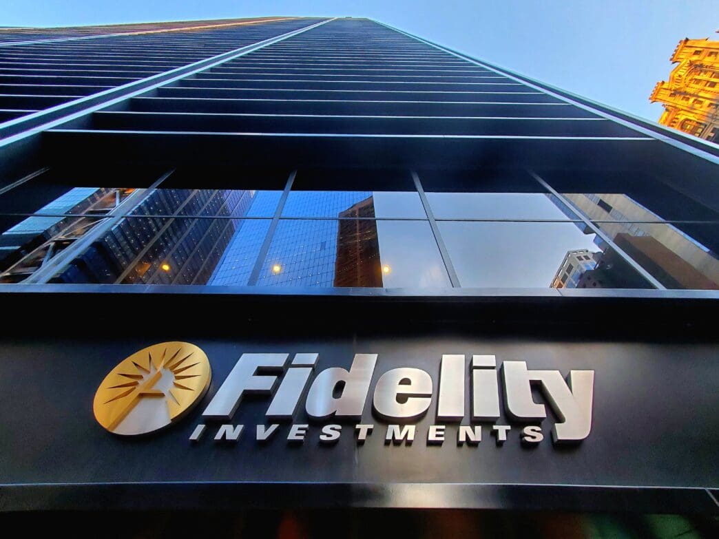 A low-angle shot of the Fidelity Investments logo on a skyscraper in New York City.