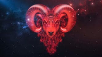 A powerful ram's head glowing with intense red light and energy against a dark, dual-colored cosmic background.