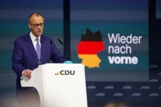 Friedrich Merz, leader of the German CDU party, speaks at a white podium with the CDU logo, against a screen with the German map and the slogan "Wieder nach vorne."