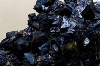 A close-up macro shot of dark, shiny Germanium crystals.
