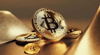 A close-up of a golden Bitcoin coin with other coins in the background