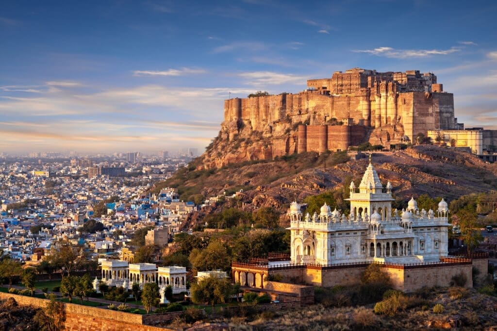 Mehrangarh Fort towering above the white marble Jaswant Thada mausoleum and the city of Jodhpur at sunrise.