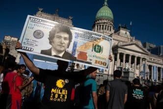 A Javier Milei supporter holds a large $100 bill with Milei's face in Buenos Aires.