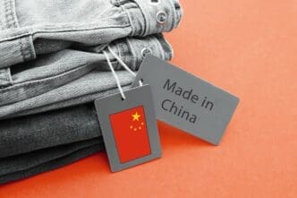 Folded grey jeans with tags showing the Chinese flag and "Made in China" text.