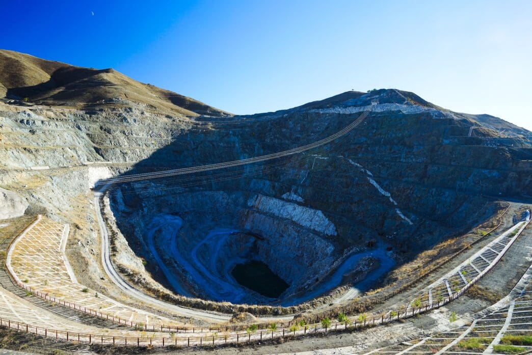 Panoramic view of the massive, terraced No 3 Mine Pit at Keketuohai, showing steep blue rock walls and a small dark lake at the bottom