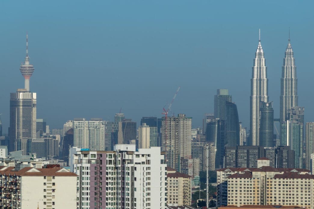 Kuala Lumpur skyline featuring the Petronas Towers and KL Tower.