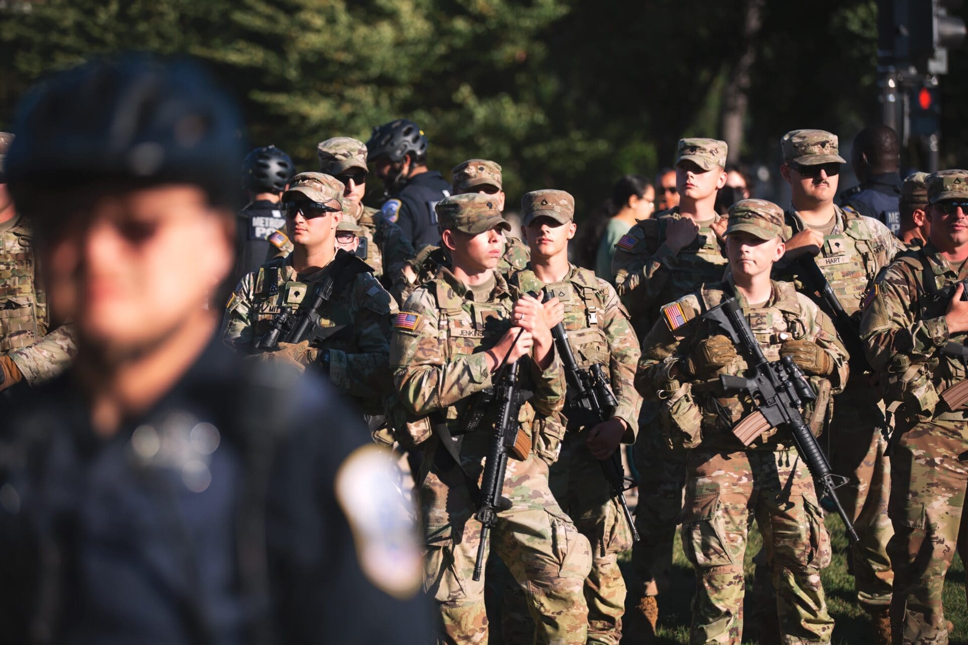 National Guard soldiers in uniform with rifles stand at attention