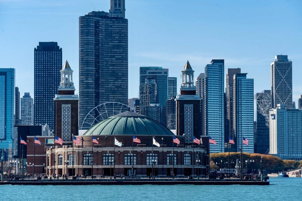 A view of Chicago's Navy Pier from Lake Michigan, with the city skyline behind it.