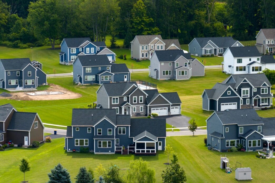 An aerial view of a new residential development in upstate New York, showing modern single-family homes and green lawns.