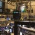 Wide interior view of the complex, multi-level New York Stock Exchange trading floor covered with screens and structural beams.