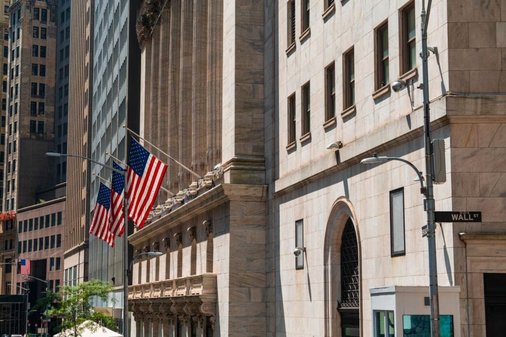 American flags hang from the stone facade of the New York Stock Exchange building on Wall Street.