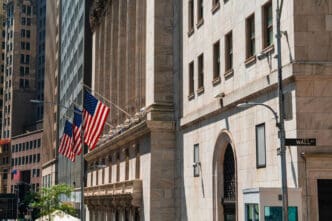 American flags hang from the stone facade of the New York Stock Exchange building on Wall Street.