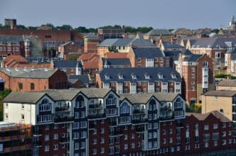 Dense view of mixed residential buildings, including modern and traditional brick structures in an urban setting.