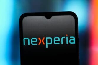 The blue and orange Nexperia logo is displayed on the screen of a smartphone against a blurred, colorful background.