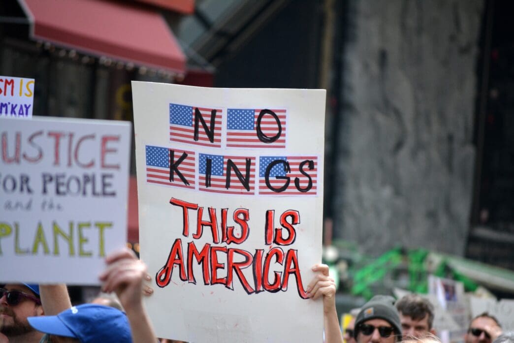 A protester holds a sign that reads "NO KINGS" and "THIS IS AMERICA" during an anti-Trump protest in New York City.
