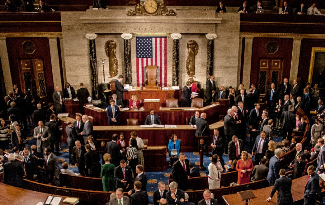 An overhead view of the U.S. House of Representatives chamber, filled with members of the 115th Congress and their families mingling.