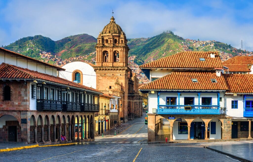The Plaza Mayor in Cusco, Peru, featuring the Basilica Menor and Andes mountains.