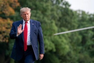 President Donald Trump waves while walking on the White House lawn in Washington DC.